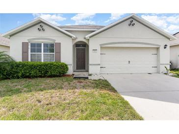 Charming single-story home featuring a well-manicured lawn and an attached two-car garage at 1864 Green Dragon Dr, St Cloud, FL 34771