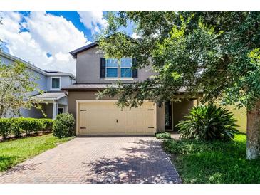 Charming two-story home with a two car garage and brick paved driveway and lush landscaping at 251 Domus Ln, Casselberry, FL 32707