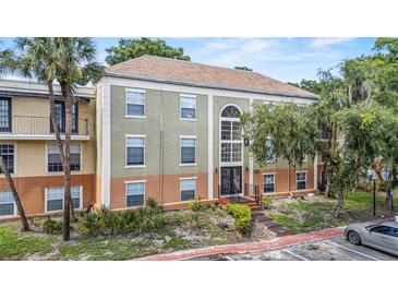 A condominium complex with a stucco exterior and well-maintained landscaping at 3946 Versailles Dr # 3946B, Orlando, FL 32808