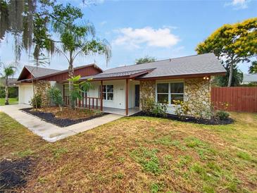 Charming home featuring stone accents, a covered porch, and a beautifully landscaped front yard at 412 Ranch Trl, Casselberry, FL 32707