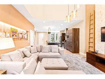 Bright living room with high ceilings, modern lighting, and a comfortable sectional sofa at 7478 Brooklyn Dr, Kissimmee, FL 34747