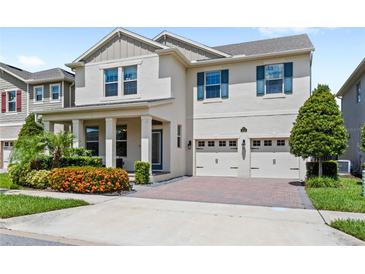 Charming two-story home features a manicured lawn, brick driveway, and a two-car garage at 9068 Sonoma Coast Dr, Winter Garden, FL 34787