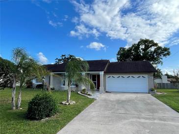 Charming single-story home with a well-manicured lawn and a two-car garage on a sunny day at 1025 Sullivan St, Deltona, FL 32725