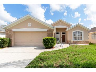 Charming single-story home featuring a well-maintained lawn and a two-car garage at 1021 Jaybee Ave, Davenport, FL 33897