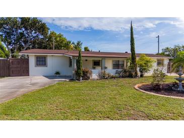 Charming single-story home featuring a well-manicured front yard with mature trees and beautiful landscaping at 1105 Arrowsmith Ave, Orlando, FL 32809
