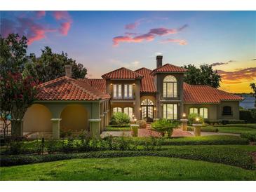 Stunning Mediterranean-style home boasting a red tile roof, lush landscaping, and a brick-paved driveway at 1351 N Classic Ct, Longwood, FL 32779