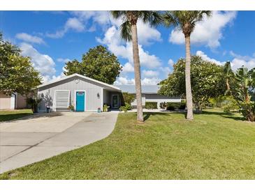 Charming single-story home with a well-manicured lawn and mature palm trees in a sunny neighborhood setting at 2356 Date Palm Dr, Edgewater, FL 32141