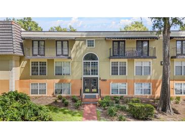 Multi-level condominium building featuring a symmetrical design and private balconies with black metal railings at 3997 Versailles Dr # 3997F, Orlando, FL 32808
