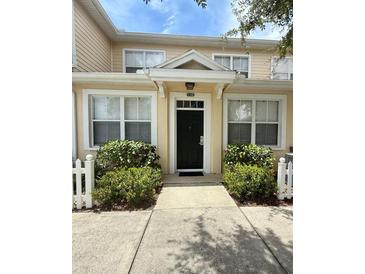 Charming townhome entrance featuring a black door, white trim, and well-maintained landscaping at 4002 San Gallo Dr # 105, Kissimmee, FL 34741