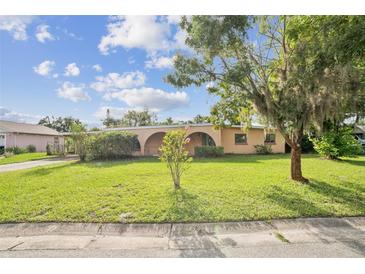 Charming single-story home with arched entryway and a well-maintained lawn on a sunny day at 5527 Sandalwood Dr, Orlando, FL 32839