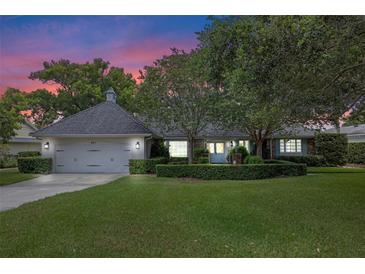 Charming single-story home with lush landscaping, mature trees, and a two-car garage at 641 Virginia Dr, Winter Park, FL 32789