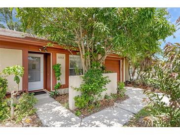 Charming single-story home featuring lush landscaping and inviting front entrance at 1032 Calanda Ave # 1032, Orlando, FL 32807