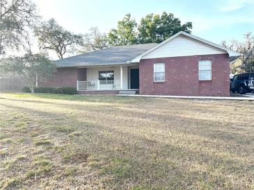 Charming single-story brick home with a welcoming front porch and well-maintained lawn at 1140 Odoniel S Loop, Lakeland, FL 33809