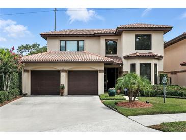 Elegant two-story home with a terracotta roof, lush landscaping, and a two-car garage in a suburban neighborhood at 1769 Turnberry Ter, Orlando, FL 32804