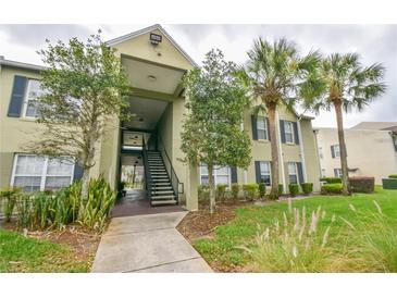 Inviting two-story building with stairs, beautiful trees and lush landscaping adds to the welcoming curb appeal at 2065 Dixie Belle Dr # O, Orlando, FL 32812