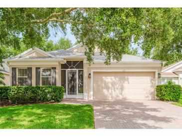 Charming single-story home featuring a brick driveway, attached two-car garage, and well-maintained landscaping at 2173 Caledonian St, Clermont, FL 34711