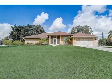 Charming single-story home featuring a spacious lawn, screened porch, and attached two-car garage at 2800 Woodsmere Ct, Kissimmee, FL 34746