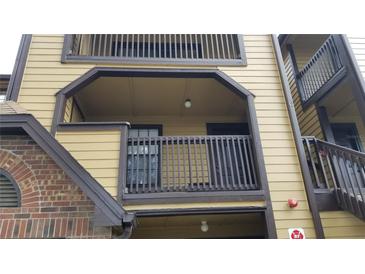 A tan apartment building with dark brown trim and railings, and a brick accent wall on the bottom left at 420 Forestway Cir # 202, Altamonte Springs, FL 32701