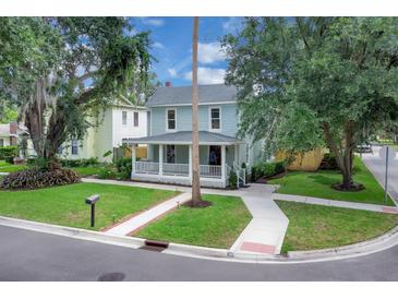 Charming two-story home featuring a quaint front porch and well-maintained landscaping in a peaceful neighborhood setting at 1021 S Elm Ave, Sanford, FL 32771