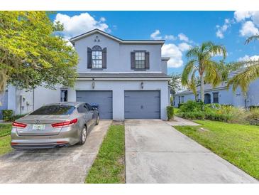 Light blue two story home featuring attached two car garages, concrete driveway and manicured front lawn at 20610 Maxim Pkwy, Orlando, FL 32833