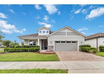 Charming single-story home with manicured lawn, brick driveway, and two-car garage at 2066 Cresswell St, Ocoee, FL 34761