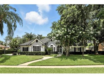 Charming single-story home with a well-manicured lawn, lush landscaping, and a welcoming front entrance at 2890 Wild Ginger Ct, Winter Park, FL 32792