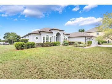 Stunning single-story home with a well-manicured lawn and beautiful landscaping on a sunny day at 3531 Oriskany Dr, Orlando, FL 32820