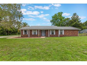 Charming single-story brick home with well-maintained lawn and mature trees providing shade at 247 Carmen Ln, Debary, FL 32713