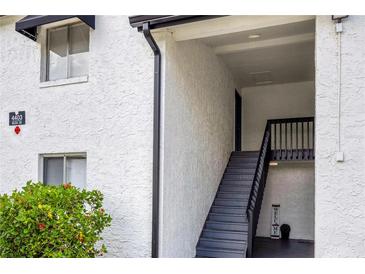Exterior view of the condo building entrance, featuring a staircase and well-maintained landscaping at 4403 S Semoran Blvd # 3, Orlando, FL 32822
