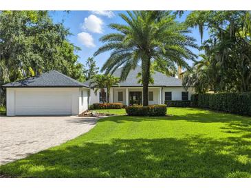 Charming single-story home with lush landscaping, brick driveway, and a spacious two-car garage at 10209 Trout Rd, Orlando, FL 32836