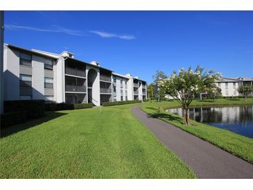 Apartment complex with well-maintained landscaping, walkway and pond at 1131 S Pine Ridge Cir # 1, Sanford, FL 32773