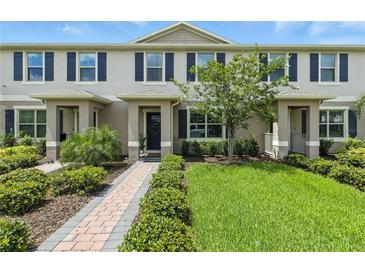 Charming townhome featuring a brick walkway, manicured lawn, and inviting entrance at 13293 Pontoon Rd, Winter Garden, FL 34787