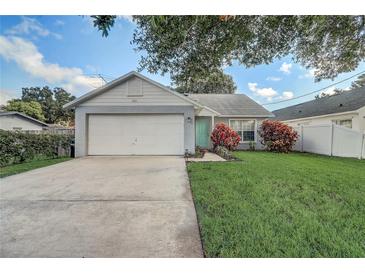 Charming single-story home with a well-manicured lawn, vibrant landscaping, and a two-car garage at 1821 Geigel Ave, Orlando, FL 32806