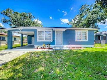 Charming blue home with a well-maintained front yard and a convenient carport at 207 Kay St, Auburndale, FL 33823