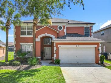 Two-story home with an attached two-car garage, neutral paint scheme, and front yard landscaping at 2705 Grand Harbour Ct, Kissimmee, FL 34747