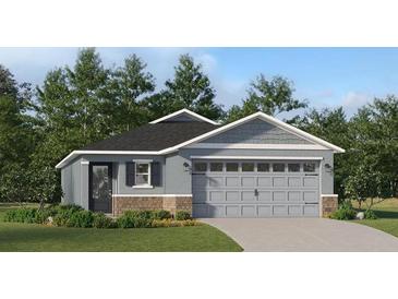 Charming single-Gathering home featuring a gray exterior, brick accents, and a two-car garage at 3751 Bergamot St, Lake Alfred, FL 33850