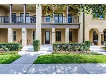 Charming townhome featuring manicured landscaping, a covered porch, and second story balcony at 4562 Lower Park Rd, Orlando, FL 32814