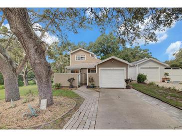 Charming home exterior featuring a well-manicured lawn, driveway, mature trees and single car garage at 503 Portland Cir, Apopka, FL 32703
