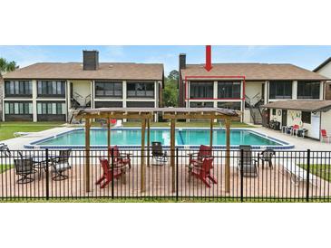 Community pool with lounge chairs and tables for residents at 563 Belltower Ave # 240, Deltona, FL 32725