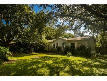 Charming single-story home surrounded by mature trees and a lush green lawn at 13010 Plum Lake Cir, Minneola, FL 34715