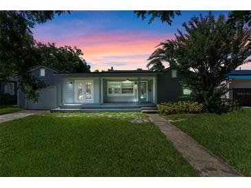 Charming single-story home with well-manicured lawn and inviting front porch at twilight at 1309 W Yale St, Orlando, FL 32804