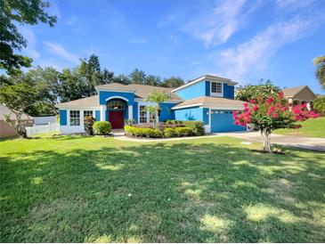Charming two-story blue home with a well-manicured lawn and beautiful landscaping at 13108 Long Pine Trl, Clermont, FL 34711