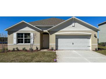 Charming single-story home with neutral siding, white trim, and a two-car garage in a well-manicured lawn at 1311 Lawndale Ct, Ormond Beach, FL 32174