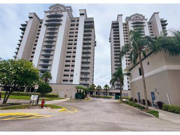 Exterior view of the two-tower condo building with manicured lawns and palm trees at 13427 Blue Heron Dr # 2-1401, Orlando, FL 32821
