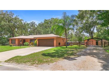 Charming single Gathering home with mature trees, neutral colors, and attached two car garage at 2678 Wilmhurst Rd, Deland, FL 32720