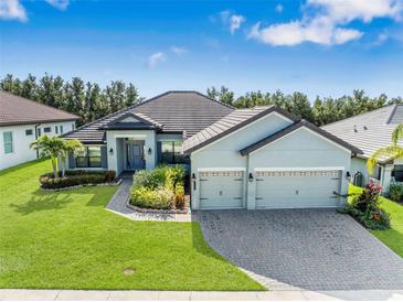 Beautiful single-Gathering home featuring a three-car garage, manicured lawn, and lush landscaping at 4940 Tennessee Lake Dr, Auburndale, FL 33823