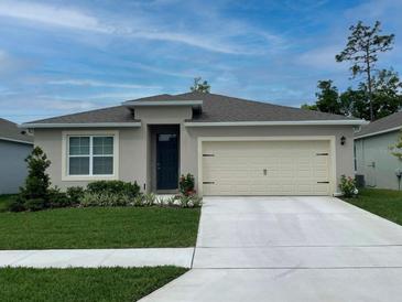 Charming single-story home with a well-manicured lawn, two car garage, and neutral exterior paint at 5147 Marshelder St, Apopka, FL 32712