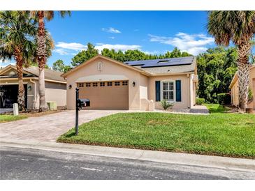 Charming single-story home featuring a two-car garage, solar panels and a beautifully landscaped lawn at 561 Vineyard Way, Poinciana, FL 34759