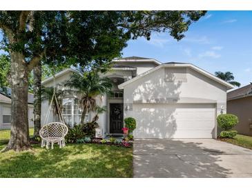Charming home featuring a two-car garage, manicured lawn, and whimsical swing at 253 Clydesdale Cir, Sanford, FL 32773