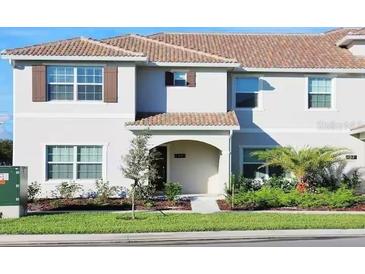 Inviting home exterior featuring a tile roof, manicured lawn, and lush landscaping at 4973 Windermere Ave, Kissimmee, FL 34746